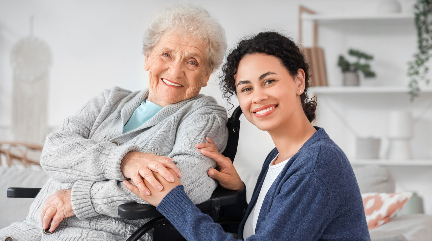 Couloir d'un établissement pour personnes âgées baigné de lumière naturelle avec une plante verte au premier plan